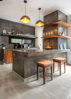 an open kitchen with two stools in front of the counter and shelves on the wall