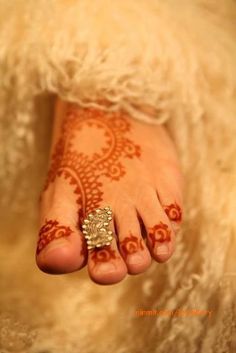 a woman's feet with hennap and ring on top of her toe