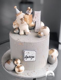 a birthday cake decorated with gold and white decorations