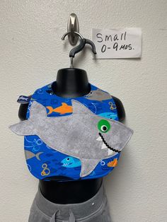 a mannequin wearing a bib with a shark on it