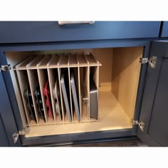 a kitchen cabinet filled with lots of different types of knives and pans in it