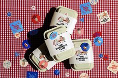 three ice cream containers sitting on top of a red and white checkered tablecloth