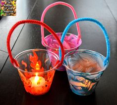 three plastic cups with candles in them on a table