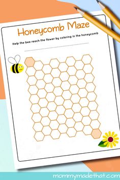 a printable honeycomb maze with two pencils next to it on a table