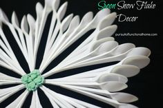 a white paper flower with green center on black background and text that reads soon snow flake decor