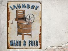 an old fashioned wash and fold sign on the side of a building with a spinning wheel