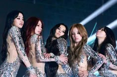 girls'generation performing on stage in sequins and bodysuits with their arms around each other