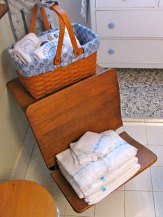 towels are stacked on top of each other in a basket next to a bed and dresser