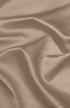 a close up view of a tan colored fabric with very soft folds and wrinkles