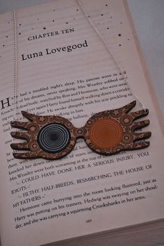 an open book with a harry potter necklace on it's front and back pages