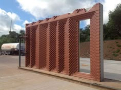 a red brick structure with holes in the middle and a mirror on it's side