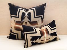 two black and white pillows sitting next to each other