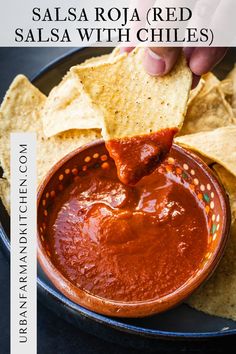 someone dipping salsa in a bowl with tortilla chips on the side and text overlay that says salsa roja red salsa with chiles