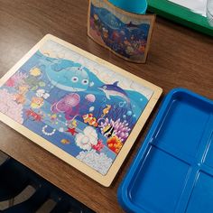 there is a puzzle on the table next to a blue tray with an animal design