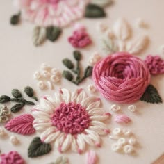 a close up of a piece of cloth with flowers on it and yarn in the middle