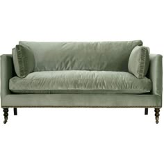 a green velvet couch with two pillows on the back and one arm upholstered