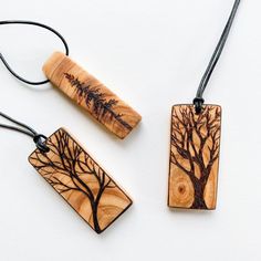 three wooden pendants with trees on them