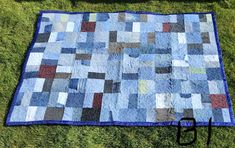 a patchwork quilt is laying on the grass