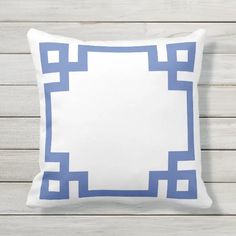 a white and blue pillow sitting on top of a wooden floor