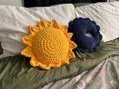 two crocheted sunflower pillows on a bed