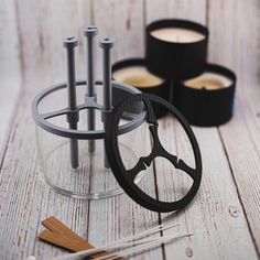 an assortment of crafting tools sitting on a table next to some candles and scissors