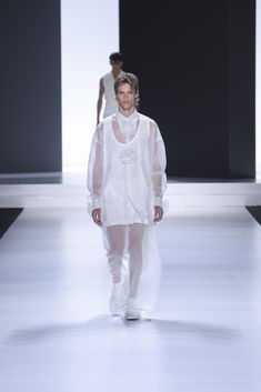 Yeray walks in an oversized organza shirt with handcrafted organza flowers, a long tank top in flame jersey with side slits and jogger-style organza pants with a 40-bottom construction. Organza Pants, Long Tank Top, Organza Shirt, Long Tank Tops, Organza Flowers, Long Tank