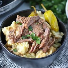 a bowl filled with meat and potatoes on top of a table