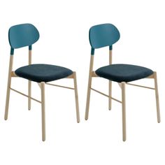 two chairs with blue upholstered back and wooden legs, one in the same color as the other