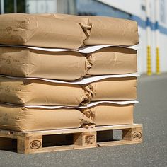 a stack of brown bags sitting on top of a pallet next to a building