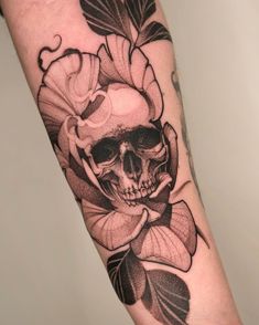 a skull and flower tattoo on the arm