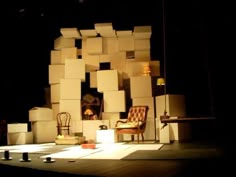 the stage is set up for a play with chairs and boxes stacked on top of each other