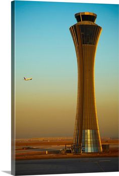 an airplane is flying in the sky near a control tower