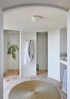 an oval rug in the middle of a room with white walls and flooring on both sides