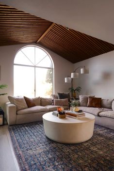 a living room filled with furniture and a large round coffee table on top of a rug