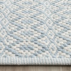 a blue and white rug on top of a wooden floor