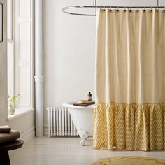 a bathroom with a bathtub, rug and shower curtain in the middle of it