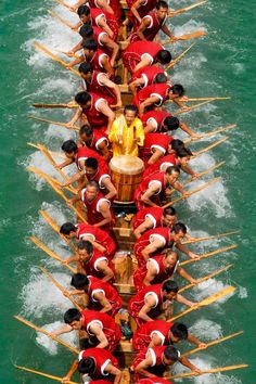 a long boat filled with people riding on top of water