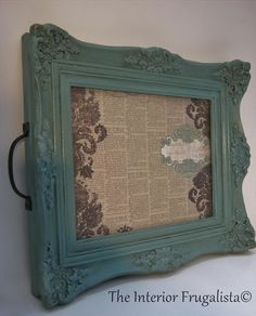 an old frame is hanging on the wall with a decorative pattern in green and brown