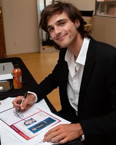 a man sitting at a table with a pen and paper