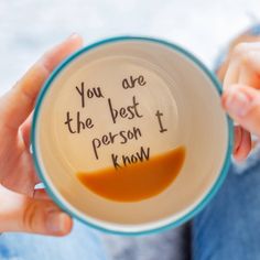 a person holding a cup with writing on it that says, you are the best person i know