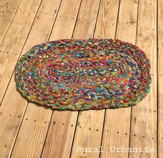 a multicolored rug sitting on top of a wooden floor next to a black cat