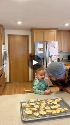 a man and his son are in the kitchen with cookies on the counter, looking at each other