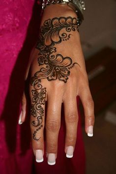 a woman's hand with henna tattoos on it