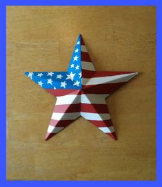 a red, white and blue paper star sitting on top of a wooden table