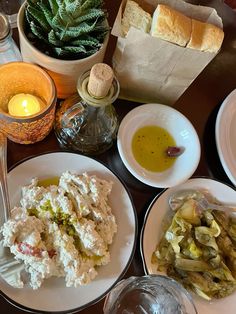 a table topped with white plates filled with food