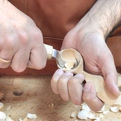 a person using a wooden spoon to cut wood