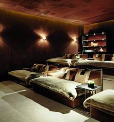 a row of beds in a room with lights on the ceiling and carpeted floor