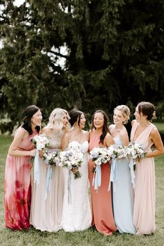 a group of women standing next to each other on top of a lush green field