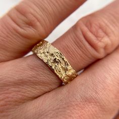 a close up of a person's hand with a gold ring on it