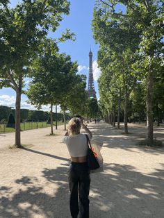 a woman is taking a photo of the eiffel tower in paris, france